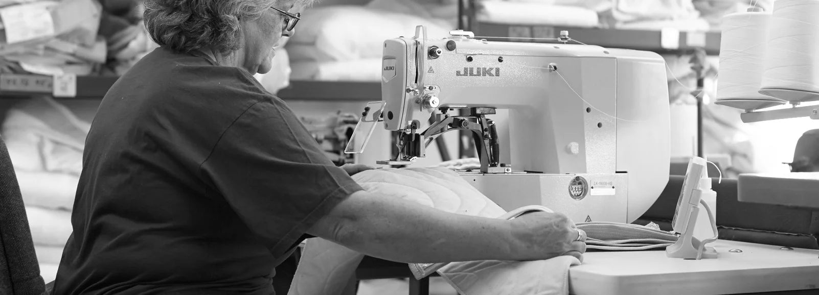 Person operating a sewing machine in a warehouse setting